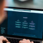 Pessoa utilizando um laptop com a interface do ChatGPT aberta na tela, exibindo as seções "Examples", "Capabilities" e "Limitations". A imagem está focada no computador, com as mãos do usuário no teclado.